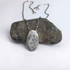 oval silver leaf pendant imprinted with ginko leaves and maidenhair fern